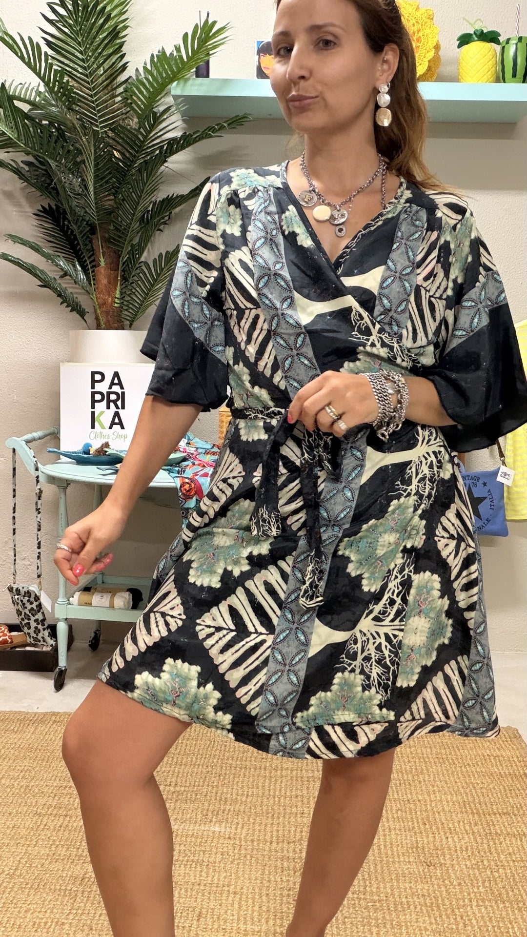 Vestido túnica curto acetinado com estampado tropical e decote trespasse