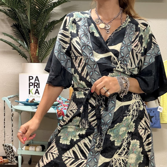 Vestido túnica curto acetinado com estampado tropical e decote trespasse