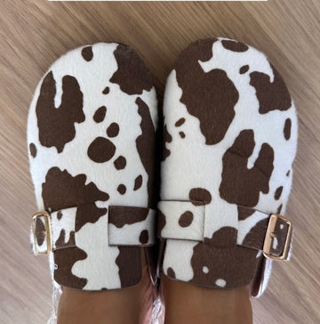 Mules em imitação de pele de vaca com fivela dourada