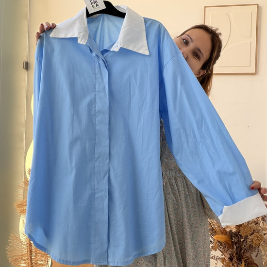 Camiseiro azul-claro com gola e punhos brancos a contrastar